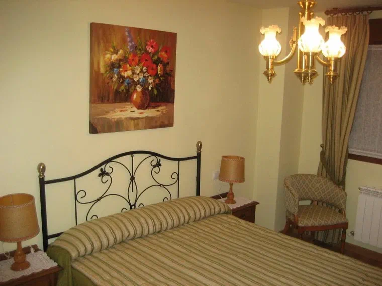 Habitación con cama de matrimonio y cabecero de forja